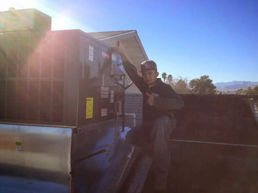 HVAC technician performing Heat Pump Repair on a rooftop unit in Bloomingdale